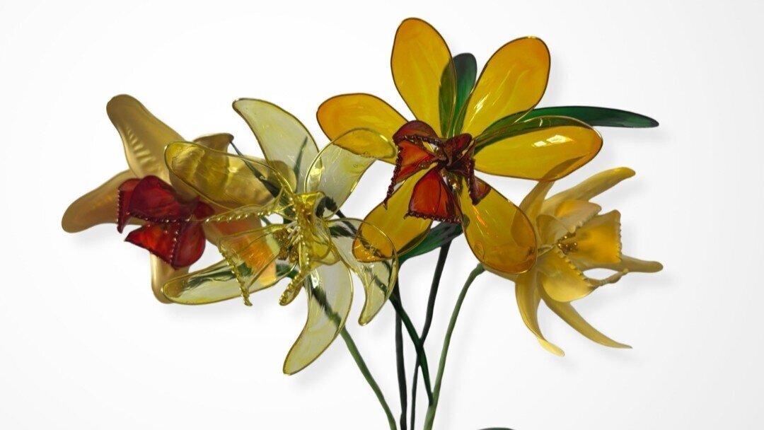 Bouquet of translucent resin dipped flowers in yellow and red tones with decorative wire stems.