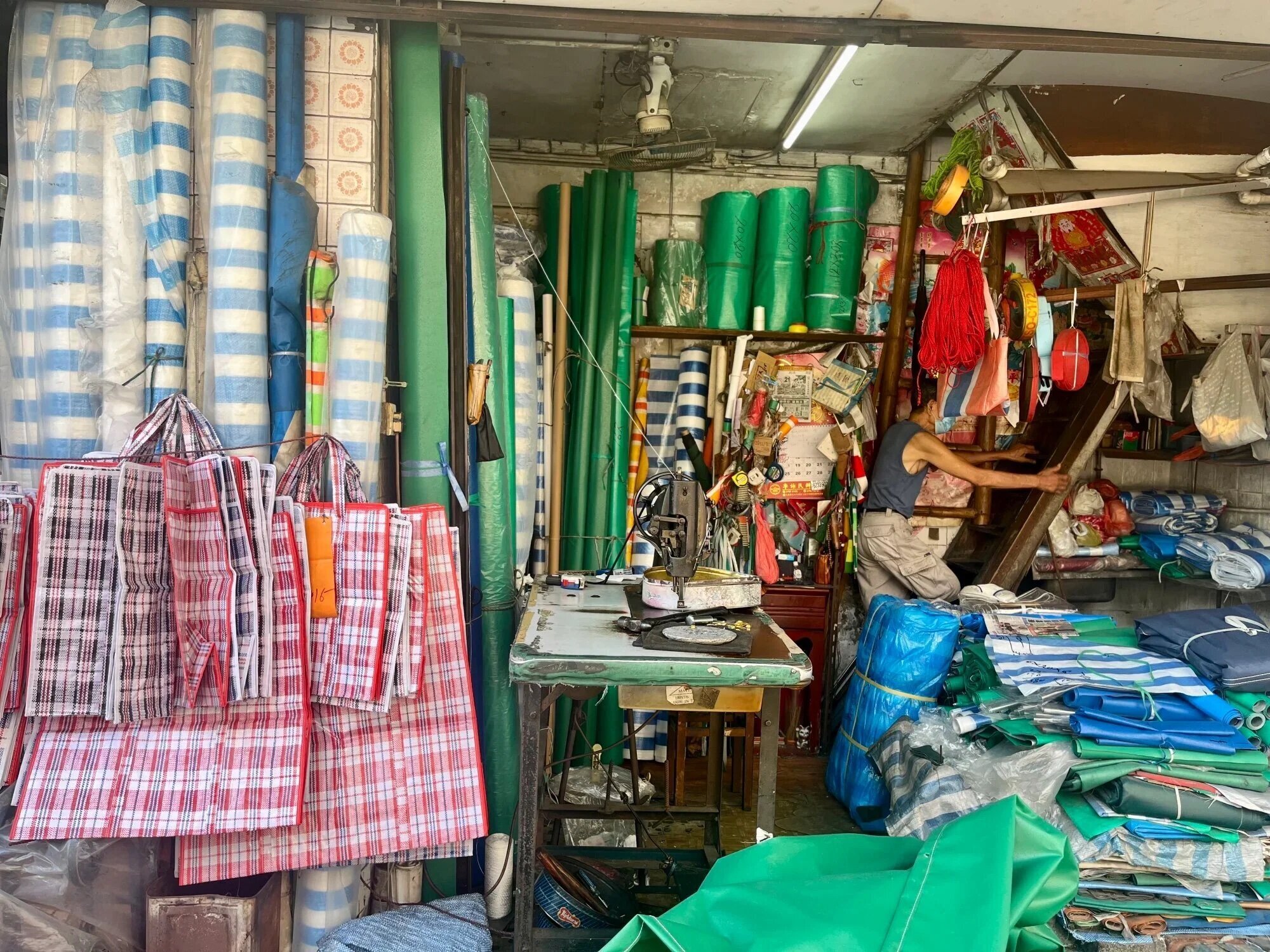 messy shop with laundry bags hanging up, bag making workshop in hong kong